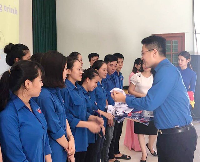 Cán bộ tỉnh Đoàn Quảng Bình trao áo quần đồng phục cho các tình nguyện viên tại lễ xuất quân "Tiếp sức mùa thi" năm 2019