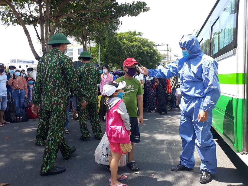 Lực lượng y tế đo thân nhiệt các "công dân nhí" trước khi lên xe trở về Quảng Bình.