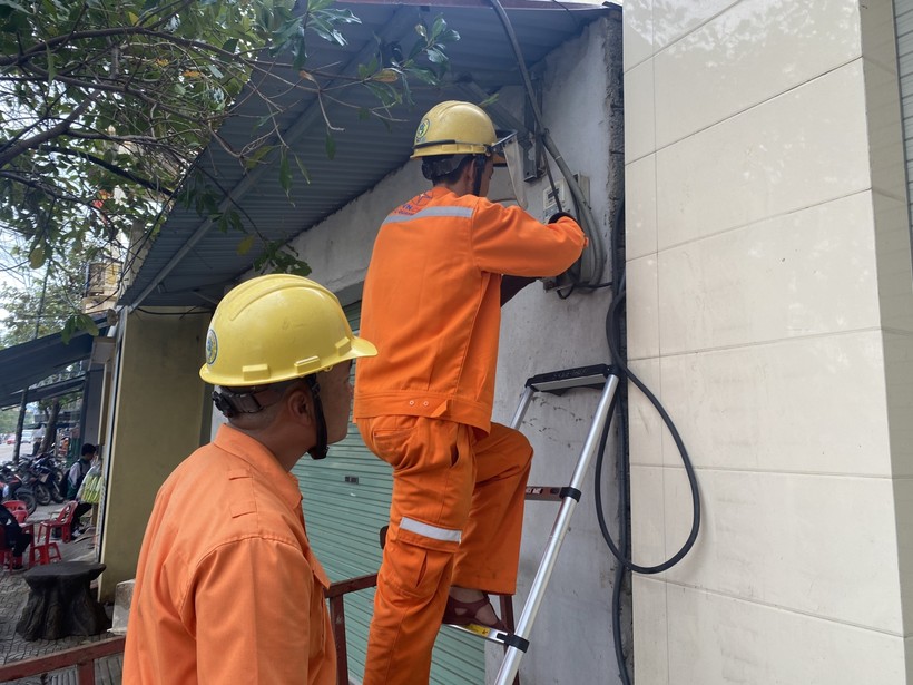 Nhân viên Điện lực Quảng Bình kiểm tra công tơ điện của các hộ dân