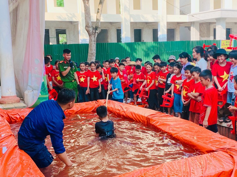 Công an xã Sơn Lâm (Hương Sơn, Hà Tĩnh) sử dụng bàn ghế cũ làm bể bơi để hướng kỹ năng phòng chống đuối nước.