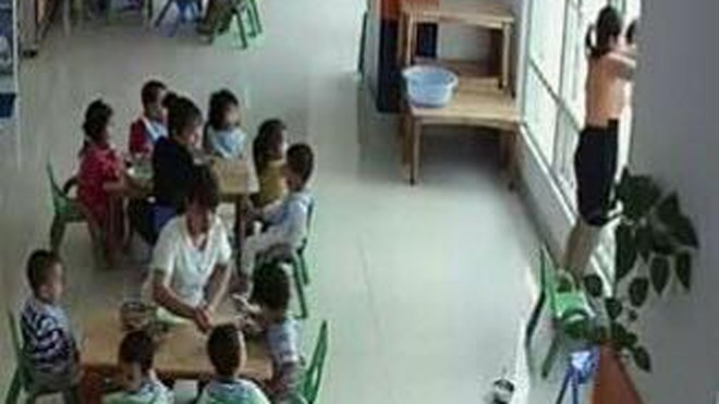 Hình ảnh cô giáo bế thốc trẻ dọa ném qua cửa sổ (ảnh trích từ Camera giám sát)