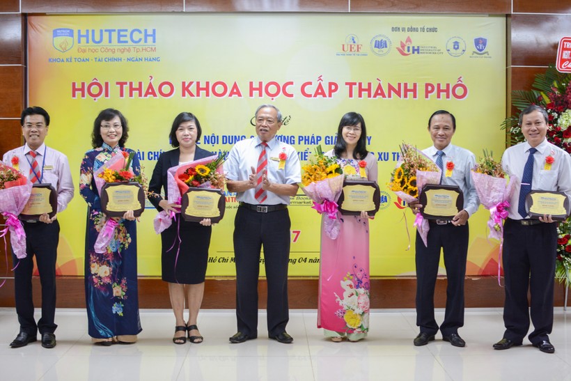 TS Kiều Tuân (giữa)- Chủ tịch HĐQT Trường ĐH Công nghệ TP Hồ Chí Minh - trao Kỷ niệm chương cho đại diện các trường trước phiên toàn thể