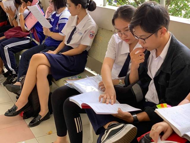 Thí sinh dự thi tại hội đồng thi THPT Phú Nhuận tranh thủ cùng nhau ôn lại bài trước giờ thi môn Toán