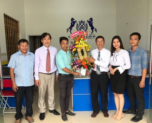 Ông Đỗ Tiến Tân - Phó giám đốc Sở LĐTB&XH tỉnh Quảng Ngãi (áo trắng) tặng hoa chúc mừng thầy cô giáo Trường Trung cấp Công nghệ Việt Mỹ
