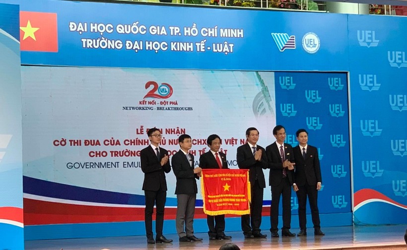 Thứ trưởng Bộ GD&ĐT Nguyễn Văn Phúc (thứ 3 từ phải qua)  trao cờ thi đua của Chính phủ tặng Trường ĐH Kinh tế - Luật (ĐHQG TP.HCM)