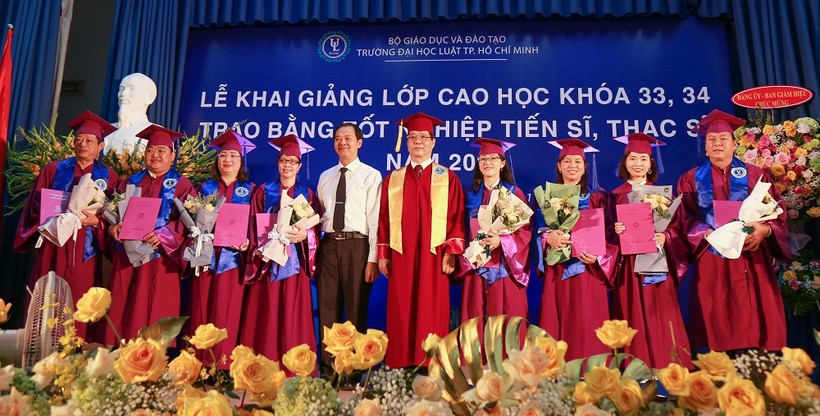PGS.TS Trần Hoàng Hải - Quyền Hiệu trưởng Nhà trường (giữa) trao bằng Tiến sĩ cho các học viên