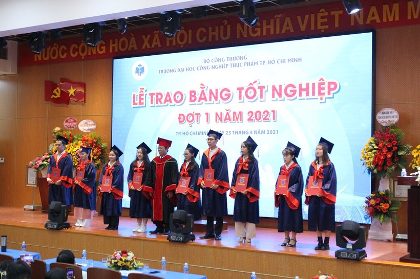  PGS.TS Nguyễn Xuân Hoàn- Hiệu trưởng HUFI (giữa) trao bằng tốt ngiệp cho các tân cử nhân 