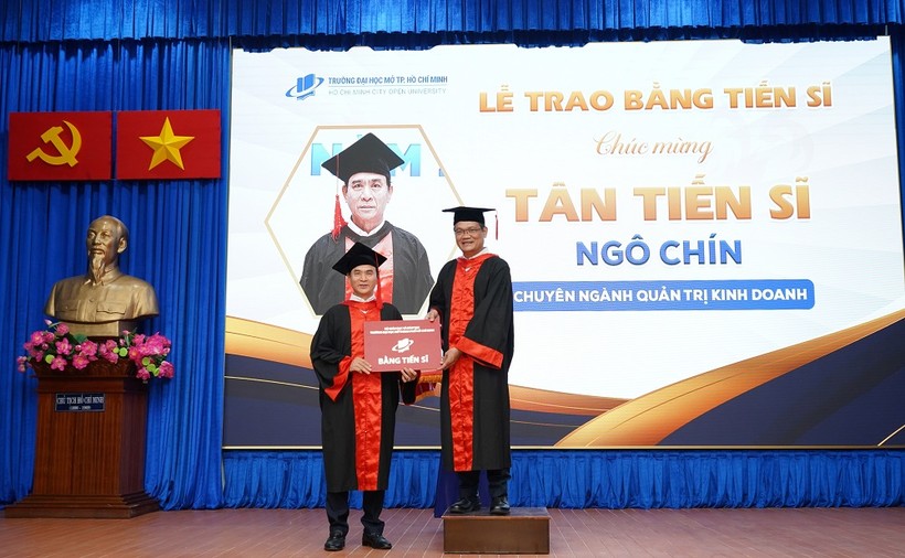 GS Nguyễn Minh Hà (phải)- Hiệu trưởng Trường ĐH Mở TPHCM trao bằng cho một tân Tiến sĩ