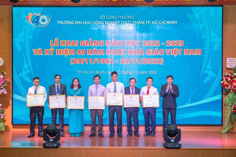 PGS.TS Nguyễn Xuân Hoàn (bìa phải), Hiệu trưởng HUFI trao bằng khen của Bộ cho các giảng viên có thành tích xuất sắc trong công tác.