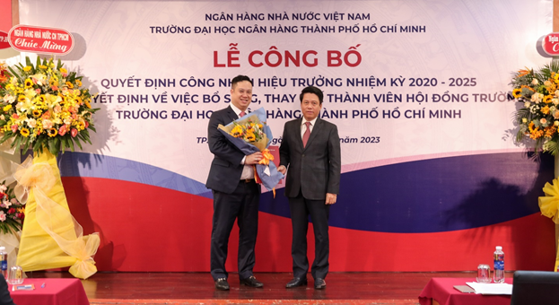 Phó Thống đốc Phạm Tiến Dũng trao Quyết định công nhận Hiệu trưởng và tặng hoa chúc mừng.