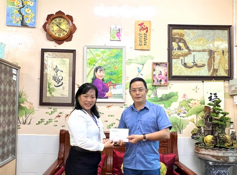 Cô Lê Thụy Phương Linh, Hiệu trưởng Trường Tiểu học Lê Văn Thọ, Quận Gò Vấp trao 30 suất học bổng cho đại diện của Báo Giáo dục và Thời đại.