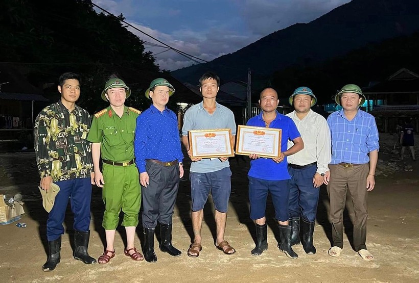 Lãnh đạo UBND huyện Kỳ Sơn tặng giấy khen cho anh Vi Văn Truyền (bên trái) và anh Lê Minh Hương vì có thành tích xuất sắc trong công tác cứu hộ, cứu nạn đợt lũ vừa qua.