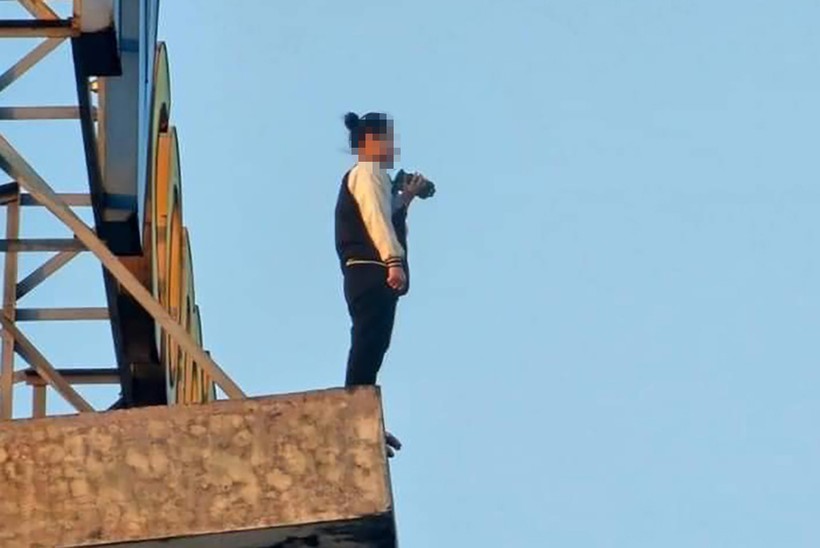 Cô gái đứng trên mép tầng thượng của tòa chung cư. (Ảnh: CACC).