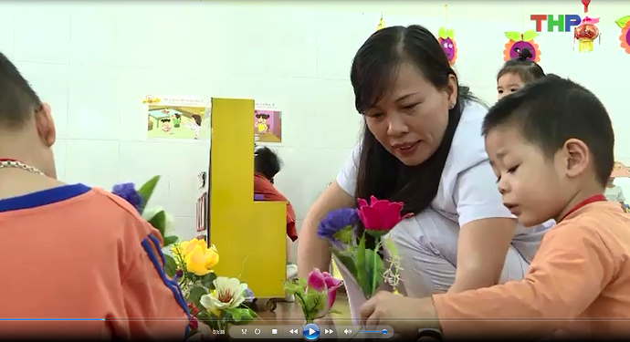 Cô giáo Lê Thị Tám đang dạy các em nhỏ cắm hoa.