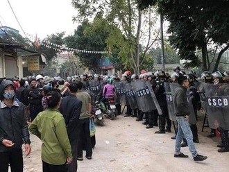 Lực lượng cảnh sát trấn áp nhóm chống đối tại xã Đồng Tâm. Ảnh: TTXVN.