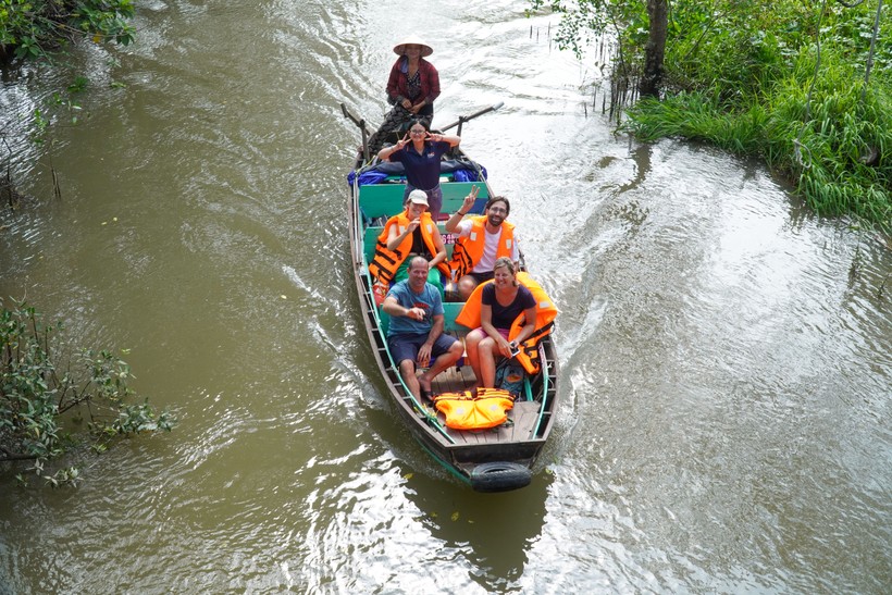 Du khách quốc tế thích thú khám phá du lịch vùng Đồng bằng sông Cửu Long.