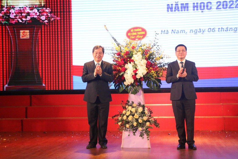 Bộ trưởng Bộ Công thương Nguyễn Hồng Diên (phải) tặng hoa chúc mừng khai giảng năm học mới 2022-2023 cho Trường ĐH Công nghiệp Hà Nội. 
