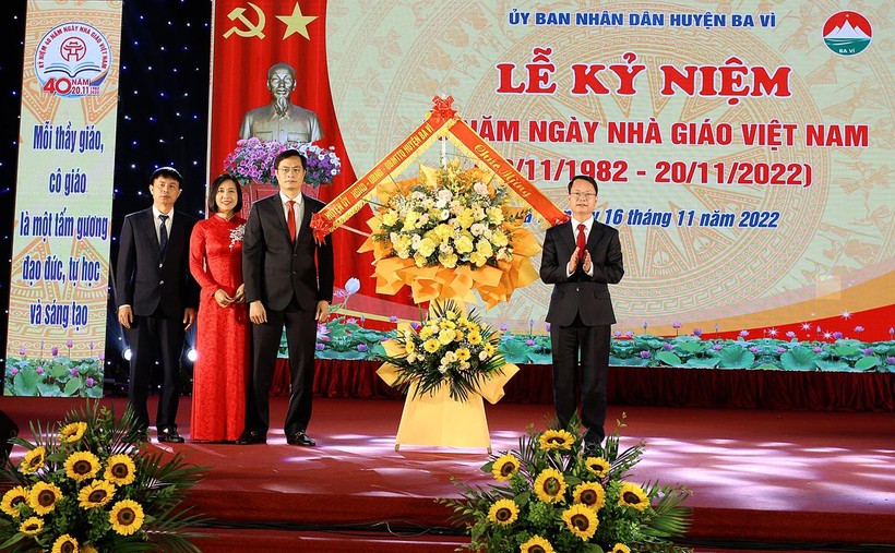 Ông Phùng Tân Nhị (phải) - Phó Bí thư thường trực Huyện ủy, Chủ tịch HĐND huyện Ba Vì thay mặt lãnh đạo huyện tặng hoa chúc mừng Phòng GD&ĐT Ba Vì.