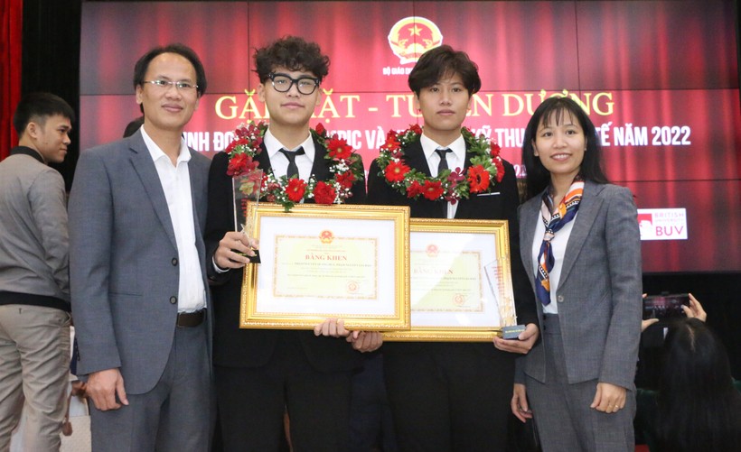 Hai em Phạm Nguyễn Quang Huy và Phạm Nguyễn Gia Bảo cùng bố mẹ trong lễ tuyên dương học sinh đạt giải Olympic và KHKT quốc tế năm 2022. Ảnh: Đình Tuệ. 