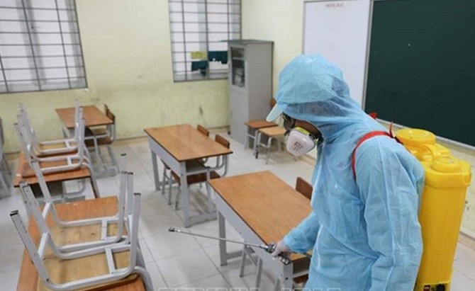 Nhân viên y tế phun khử khuẩn phòng chống dịch bệnh tại Trường Tiểu học Văn Võ (Chương Mỹ, Hà Nội). Ảnh: TG.