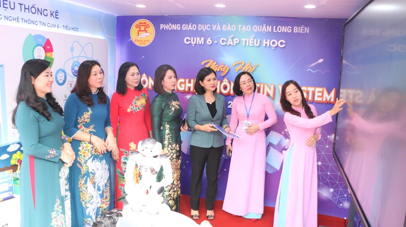 Cô Nguyễn Huyền Trang (bìa phải) - giáo viên Trường Tiểu học Đô thị Sài Đồng giới thiệu cho các đại biểu về một số ứng dụng thông minh mà nhà trường triển khai.