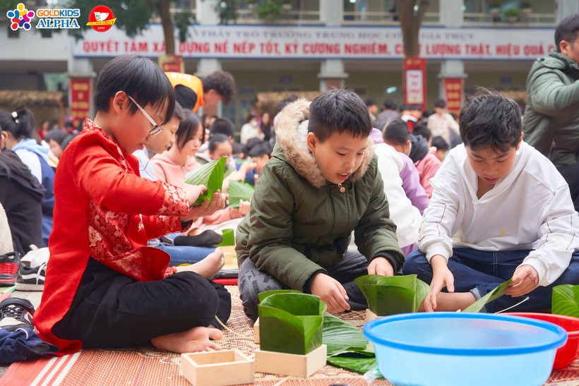 Học sinh Trường THCS Gia Thụy (Long Biên, Hà Nội) cùng nhau gói bánh chưng tại sân trường. 