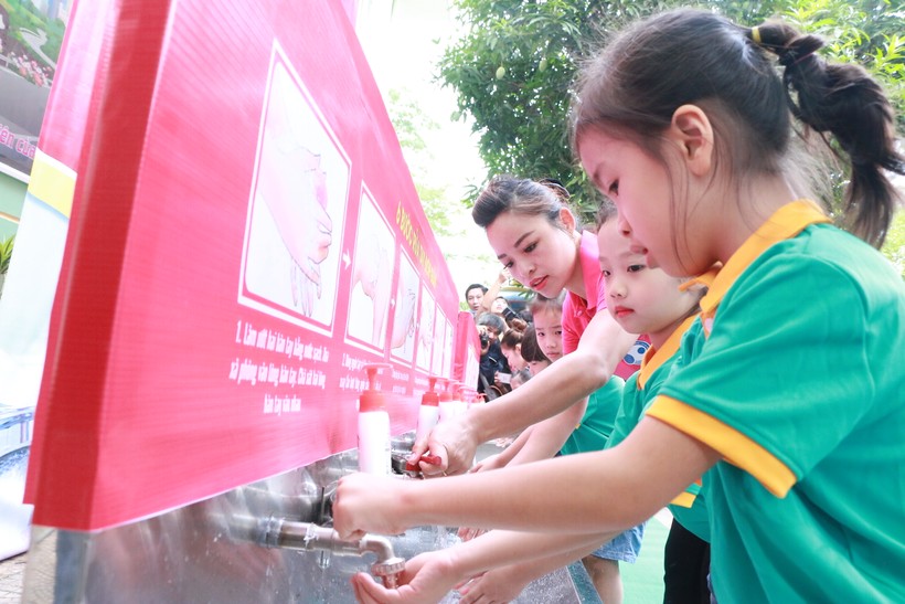 Cô trò Trường Mầm non Dịch Vọng Hậu (Cầu Giấy, Hà Nội) cùng nhau rửa tay bằng xà phòng dưới vòi nước chảy. Ảnh: Đình Tuệ.