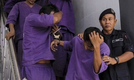 Cảnh sát dẫn giải các nghi phạm hiếp dâm tới một phiên tòa ở Malaysia. Ảnh: Independent.