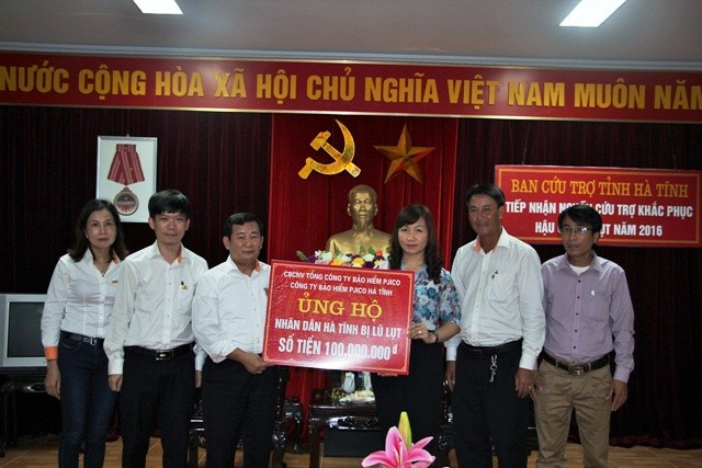 Giám đốc Công ty Bảo hiểm Pjico Hà Tĩnh Nguyễn Xuân Hoàng trao 100 triệu đồng hỗ trợ bà con nhân dân sau đợt lũ .

