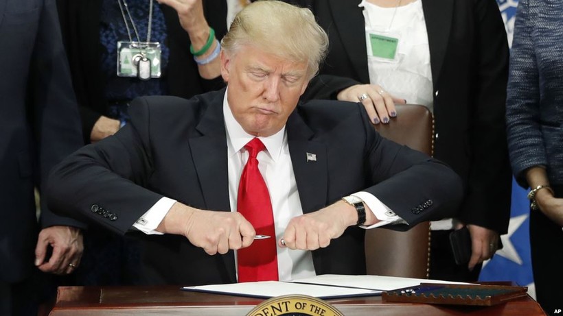 Tổng thống Donald Trump mở nắp bút trước khi ký sắc lệnh về di trú tại Bộ An ninh nội địa ngày 25/1/2017