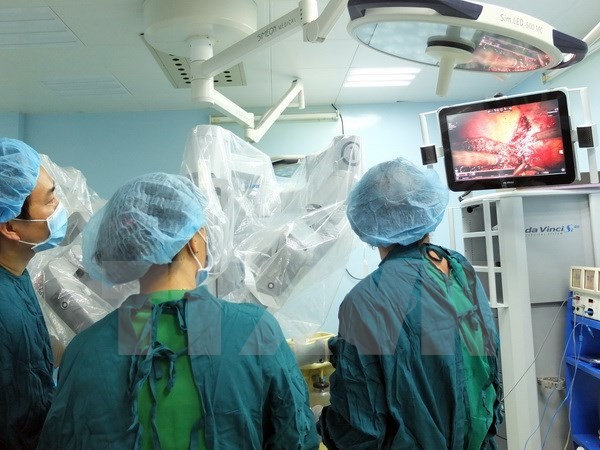 Các bác sỹ Khoa Ngoại Gan Mật(Bệnh viện Bình Dân) thực hiện phẫu thuật robot cắt trọn vẹn hạ phân thùy gan II, III cho người bệnh. Ảnh: TTXVN