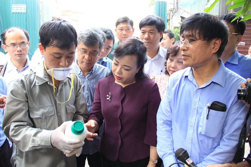 
Bộ trưởng Bộ Y tế kiểm tra lọ dung dịch hóa chất dùng để phun diệt muỗi. Ảnh: Báo Sức khoẻ và Đời sống