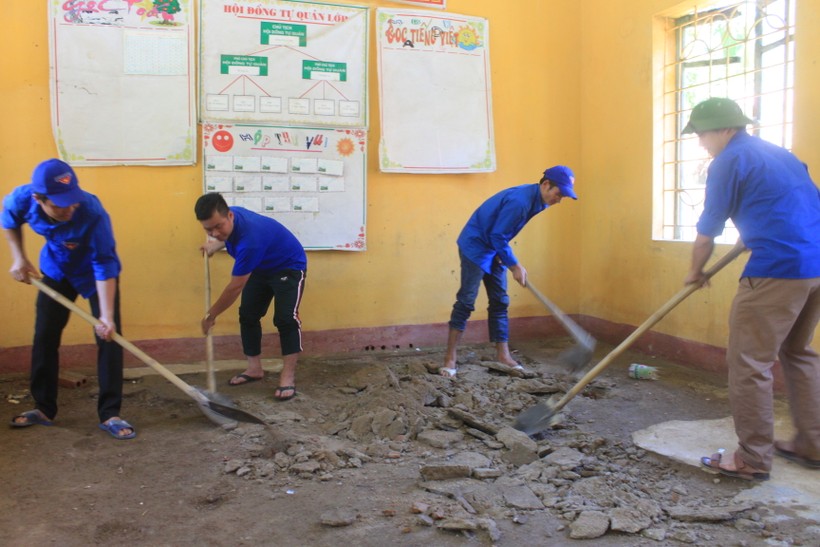 Các bạn ĐVTN đang bóc nền cũ để lát gạch mới tại phòng học xuống cấp của Trường tiểu học xã Tân Phúc, huyện Lang Chánh (Thanh Hóa) - Ảnh: Nuyễn Quỳnh