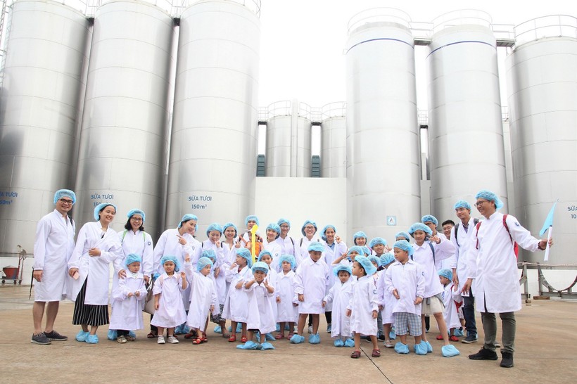 Các bé chụp ảnh cùng bố mẹ tại khu vực bồn chứa sữa tươi khổng lồ của nhà máy