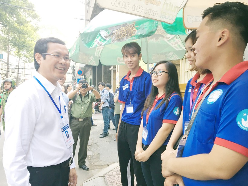 Thứ trưởng trò chuyện cùng sinh viên tình nguyện tại điểm thi Trường THPT Bùi Thị Xuân