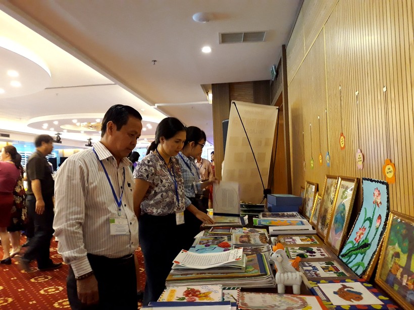 Các đại biểu xem trưng bày sản phẩm thư viện thân thiện tại hội thảo.