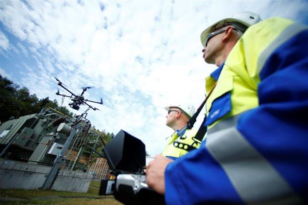 Công nhân vận hành drone để khảo sát đường dây điện cao áp của công ty điện Westnetz của Đức