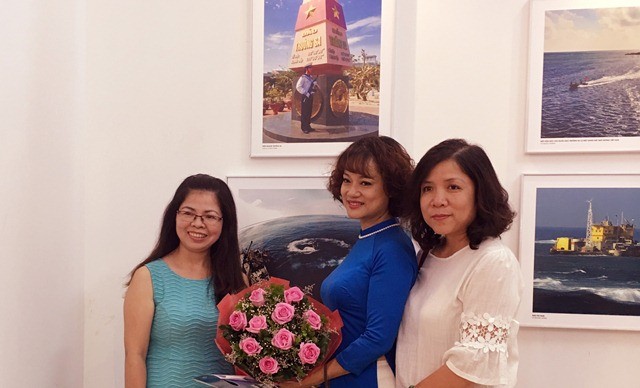 Nhà báo Nguyễn Mỹ Trà (đứng giữa) cùng bạn bè	đồng nghiệp trong ngày triển lãm ảnh "Trường Sa trong ta"