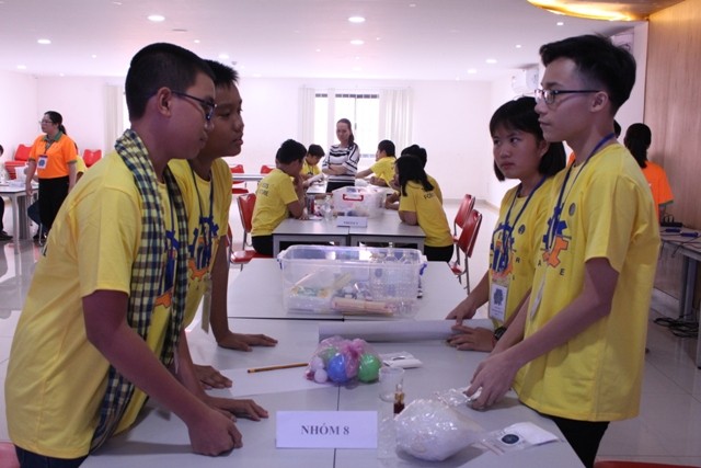 Tom Phí Trung Việt – lớp 9 (bìa phải) thảo luận với nhóm được phân công ngẫu nhiên trong vòng 2 – Maker Day của chương trình STEM Ambassadors.