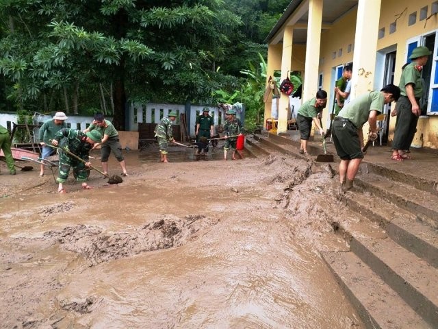 Công an và Quân đội giúp trường Phổ thông dân tộc bán trú - THCS Tam Chung nạo vét bùn đất.