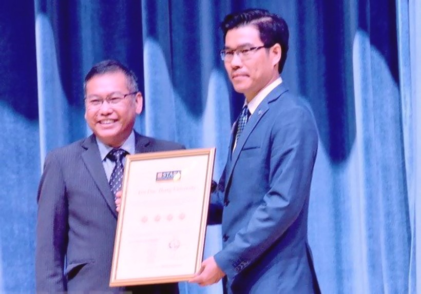 Đại diện QS Stars University Raitings (trái) trao chứng nhận xếp hạng 4 sao cho đại diện lãnh đạo Trường ĐH Tôn Đức Thắng