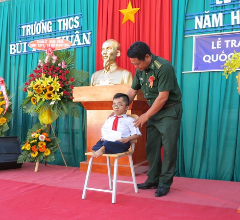 Đại diện Bộ đội Biên phòng Khánh Hòa trao học bổng tiếp sức đến trường cho một em học sinh lớp 9.ảnh baokhanhhoa

