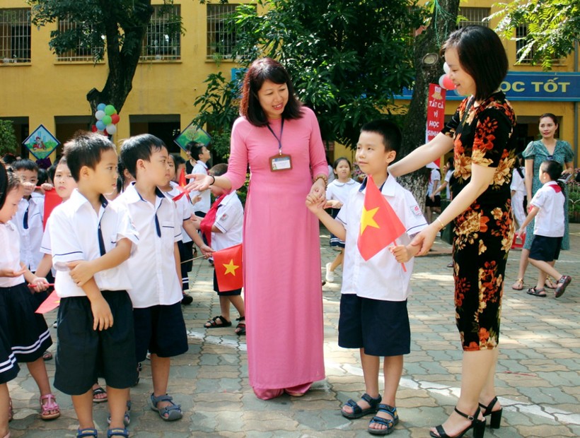 Cô giáo Phạm Kim Anh (Trường Tiểu học Kim Liên, Hà Nội) nở nụ cười tươi tắn, đón cậu học trò nhỏ được mẹ giao tận tay cô giáo (với nhiều tâm tư gửi gắm, hy vọng) trong ngày khai trường