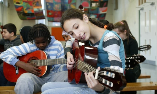 HS học cách chơi guitar trong một giờ học âm nhạc ở trường trung học tại London