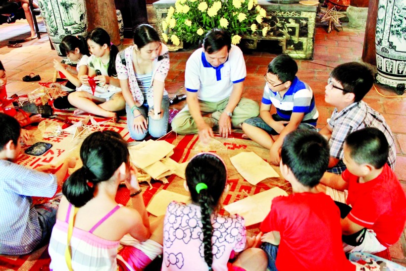 Trẻ em được nghệ nhân dạy cách làm đồ chơi truyền thống trong không gian văn hóa phố cổ