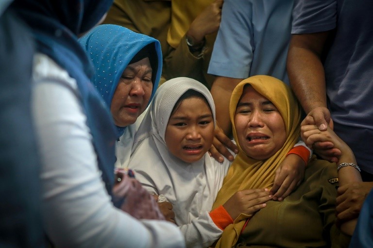 Nhiều người thân của các nạn nhân đang ở bên ngoài một bệnh viện tại Jakarta