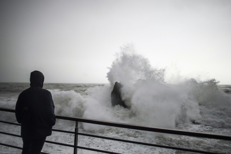 Một người dân đứng nhìn những cột sóng lớn trong cơn bão ở miền Nam nước Ý