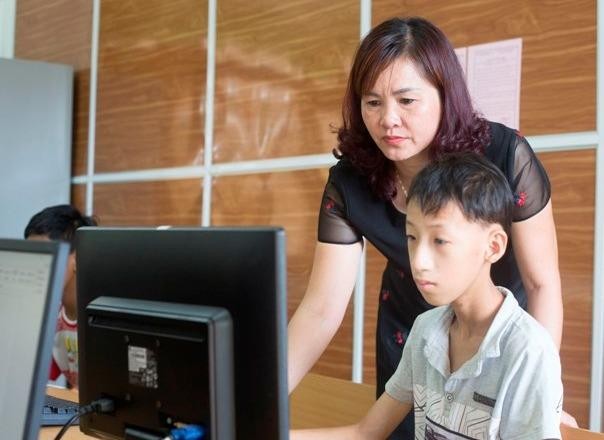 Chị Nguyễn Thị Bích Phương hướng dẫn học sinh khuyết tật thực hành môn Tin học