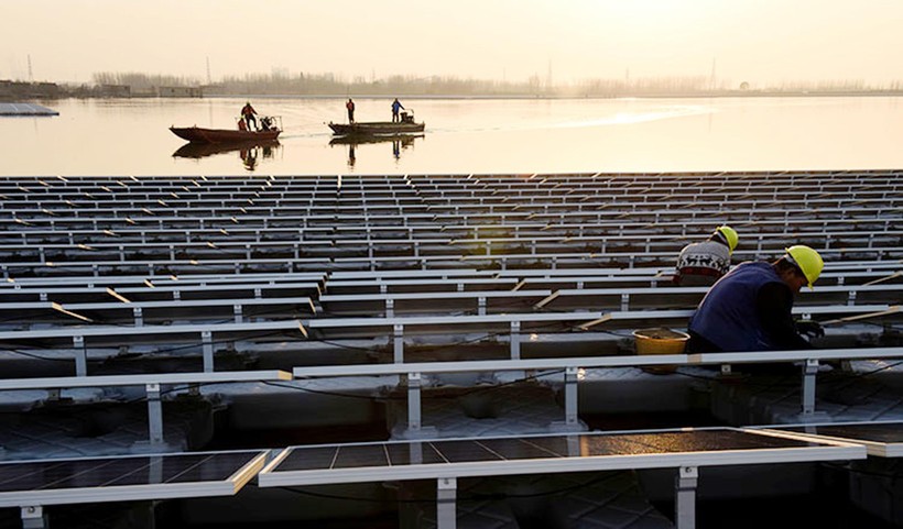 Công nhân lắp đặt các tấm pin Mặt trời tại một nhà máy năng lượng Mặt trời nổi trên mặt hồ ở tỉnh An Huy, Trung Quốc