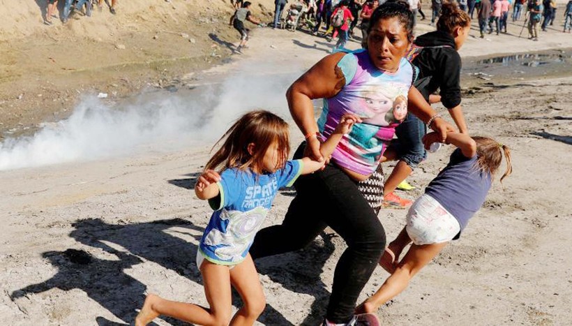 Một gia đình di cư chạy khỏi luồng khí cay ở biên giới Mỹ - Mexico khu vực Tijuana